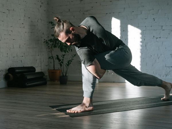 A serene corner for yoga with a mat, plant, and soft light.